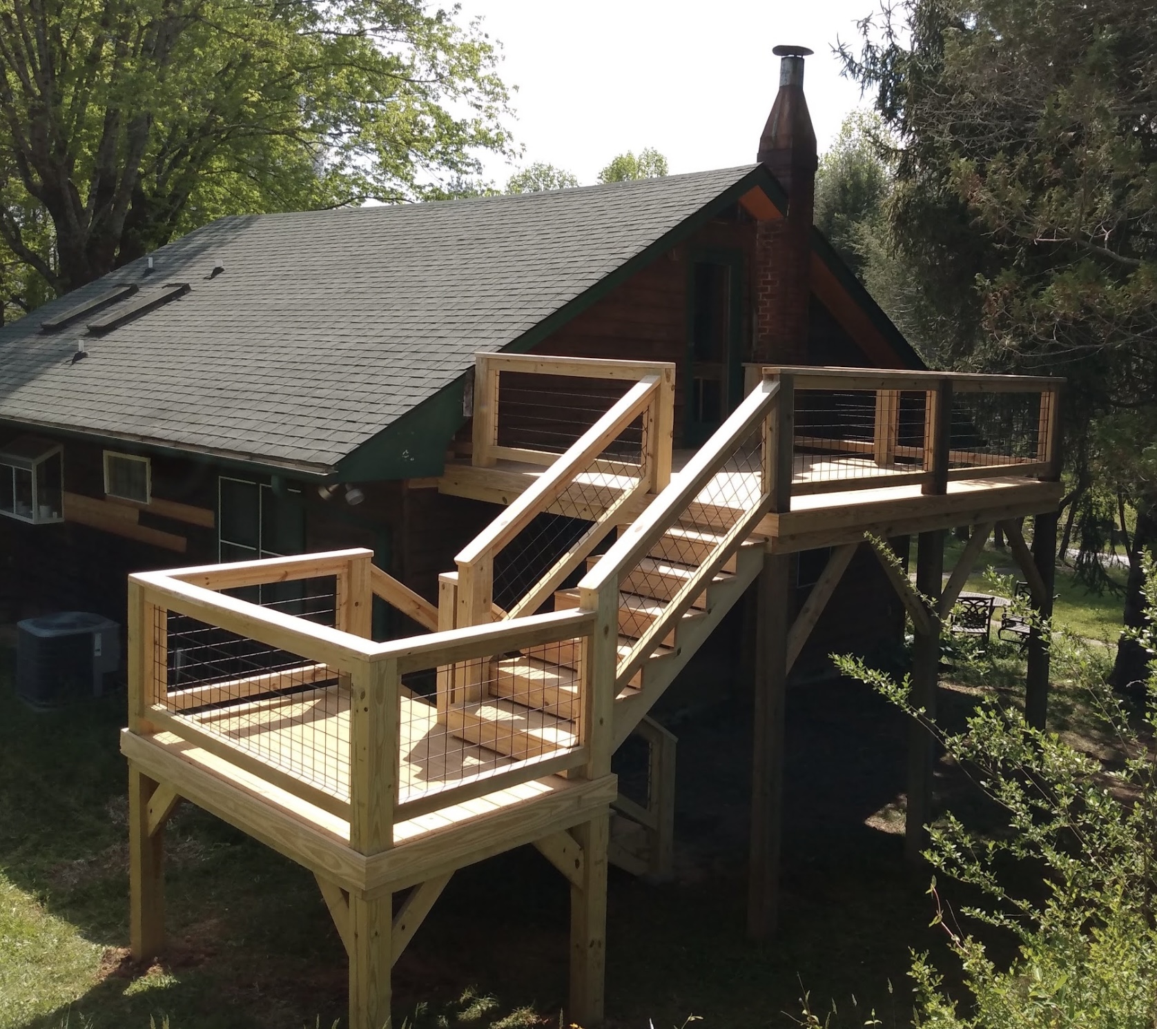 Multi-level deck with wide staircase on log cabin — WNC